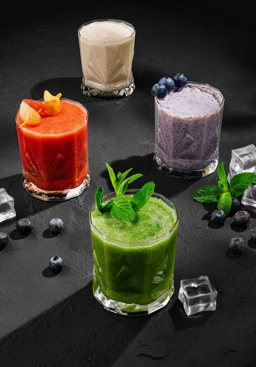 Freshly blended fruit smoothies of various colors and tastes in glass